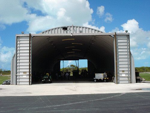 Arched steel aircraft hangar with doors open