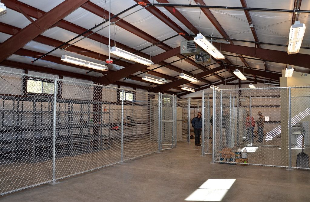 Interior of a pre-engineered steel building with red portal frames and purlins
