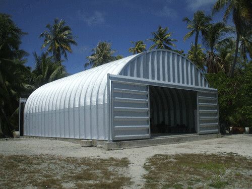 Freestanding arched steel shed among palm trees