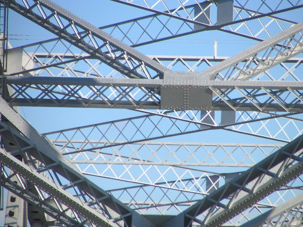 Riveted steel truss members intersecting overhead